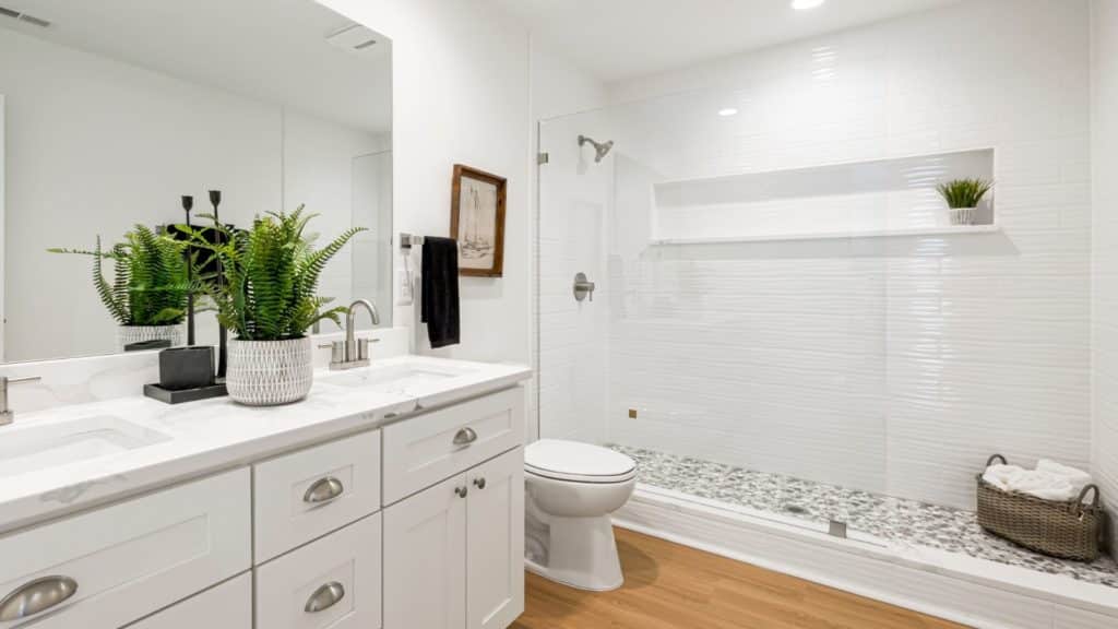 White bathroom with vanity, toilet, and shower