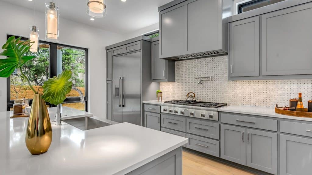Kitchen with gray cabinets and white tops