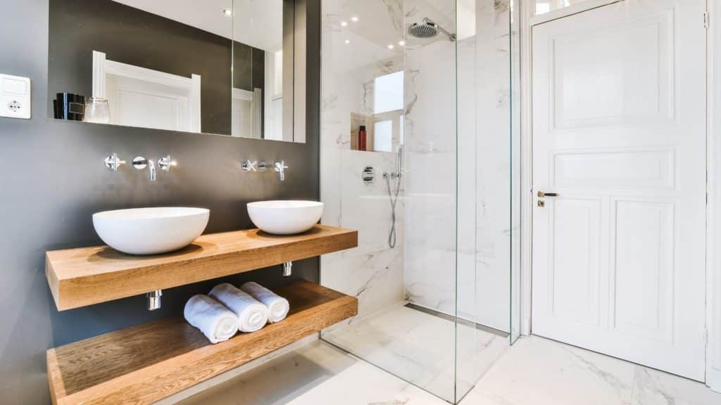 Bathroom with shower and 2 vessel sink on top of floating wood