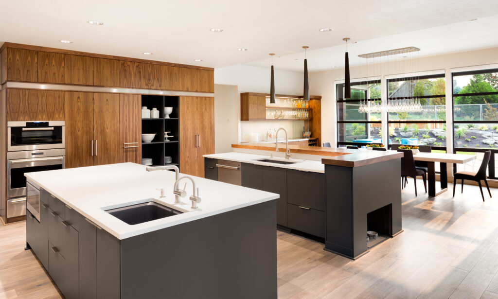 Beautiful Kitchen Interior with Two Islands, Two Sinks, Cabinets, and Hardwood Floors in New Luxury Home