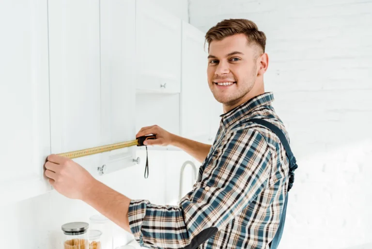 Man measuring kitchen cabinets