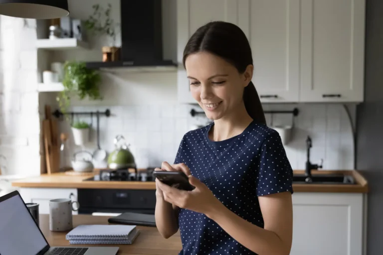 Female using phone in kitchen